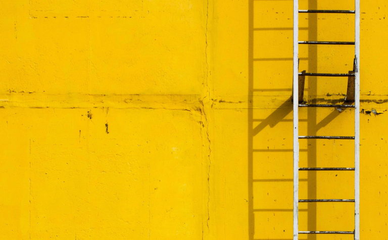 Ladder against yellow wall