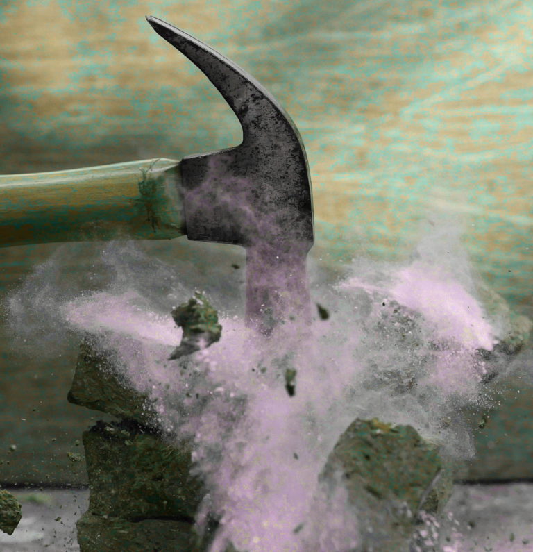 A hammer strikes a block, causing a burst of purple dust and debris. The action is dynamic, capturing the moment of impact against a textured, greenish background.